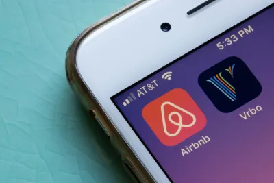 Close-up of mobile phone with Airbnb and VRBO app icons.