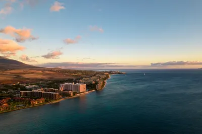Aerial view of coast in Maui, hawaii with hotels and condo buildings at sunrise or sunset.