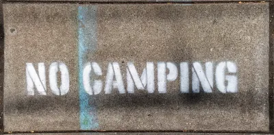 "No Camping" stencil on concrete.