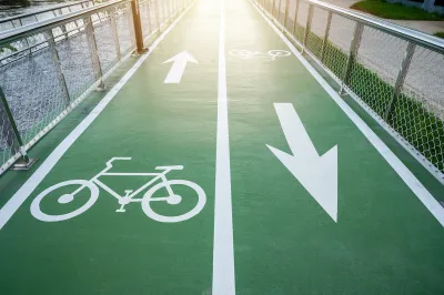 Green painted two-way bike lane with bike symbols and arrows.