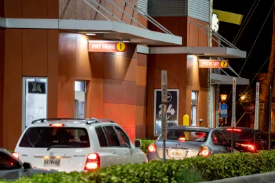 Line of cars at a McDonald's drive-thru at night.