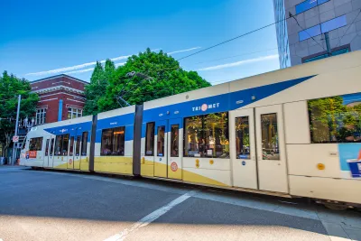 White and blue TriMet MAX light rail train on street in Portland, Oregon.