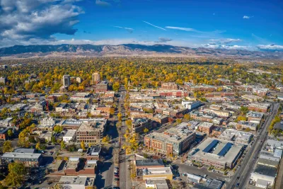 Aerial view of Fort Collins, Colorado on sunny day with mountains in background.
