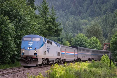 AMtrak train passing through dense green forest in Index, Washington.