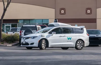White Waymo self-driving car in parking lot in Chandler, Arizona.