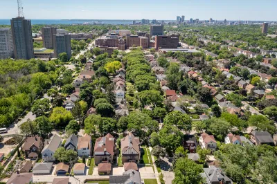 Aerial view of homes in Milwaukee, Wisconsin with brick university buildings in distance.