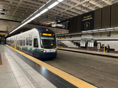 White and blue Seattle Link light rail train pulling into station in Seattle, Washington.