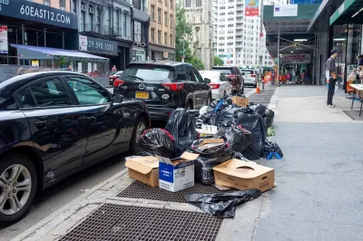 Parked cars and bags of trash on New York City sidewalk.