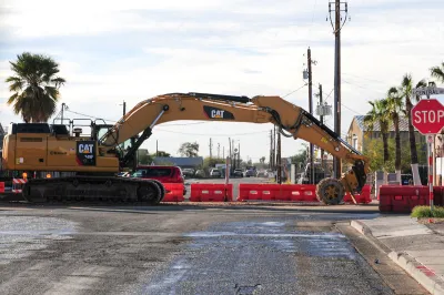 Yellow Cat heavy equipment working on light rail construction on road in Phoenix, Arizona.