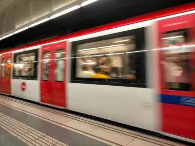 Red and white Barcelona Metro train passing through station.