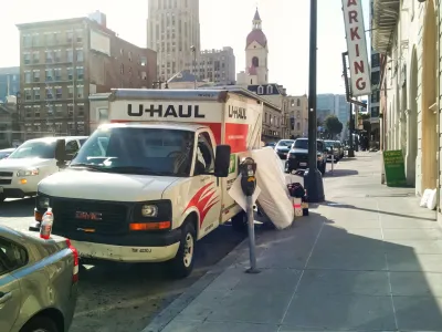 U-Haul moving van parked by a curb in San Francisco with mattress leaning against it