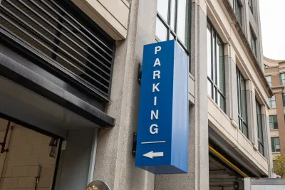 Blue sign with white Parking text and arrow pointing into garage