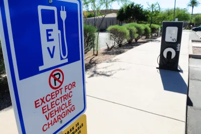 Close-up of EV charging station sign with "No Parking except for EV charging" in outdoor parking lot.