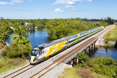 Aerial view of yellow Brightline high-speed rail train in Deerfield Beach, Florida.