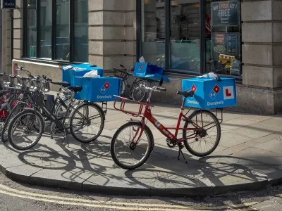 Domino's Pizza delivery bikes parked on a sidewalk in London, UK.
