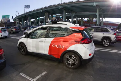 White and red Cruise self-driving vehicle on a San Francisco street.