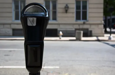 Close-up of black parking meter with blurred street in background