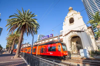 Red San Diego trolley in front of 1915 Neo-Spanish building at Santa Fe Depot in downtown San Diego, California.