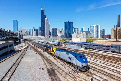 Amtrak train at Union Station with Chicago skyline in background.