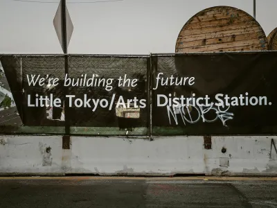 Black banner with white text "We're building the future - Little Tokyo/Arts District Station" in Los Angeles, California.
