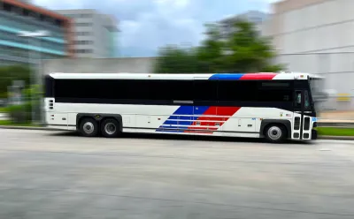 Houston Metro bus moving rapidly across blurred background.