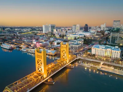 View of Tower Bridge over Sacramento River and downtown Sacramento, California at dusk.