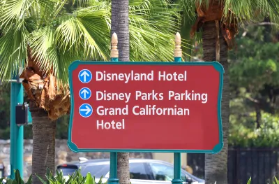 CLose-up of red outdoor sign for Disneyland Hotel, Disney Parks Parking, and Grand Californian Hotel in Anaheim, California.