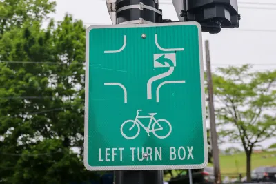 Close-up of green sign for bike box for turning in intersection.