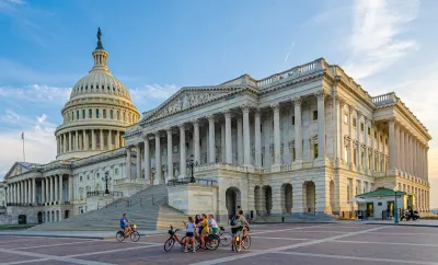 Wide shot of group of people with bikes standing in plaza near U.S. Capitol in Washington, D.C.