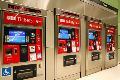 Row of four red and white MUNI ticketing machines in transit station in San Francisco, California.