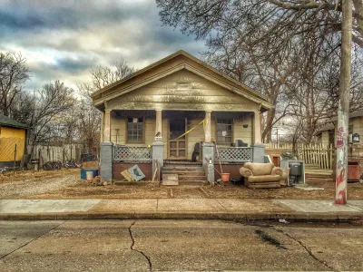 Old single-story home with porch in run-down condition