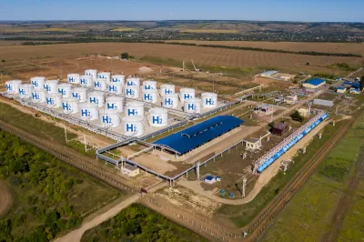 Aerial view of hydrogen storage hub in green field.