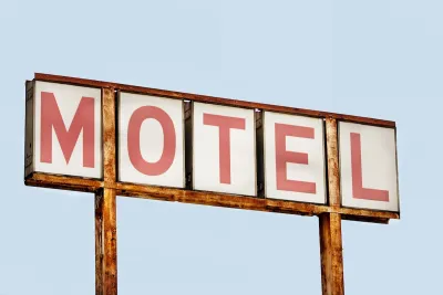 Close-up of faded old MOTEL sign with red letters on white placards against blue sky.