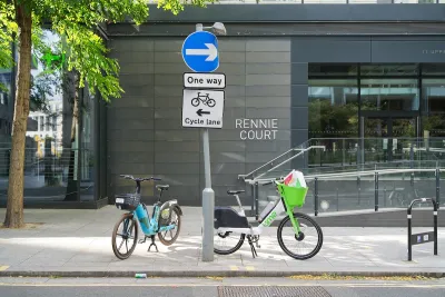 Two electric dockless bikes parked on sidewalk in London, UK.