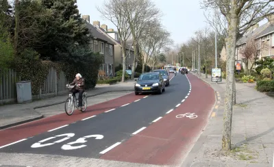 Advisory bike lane in The Netherlands with bike rider and cars in center lane