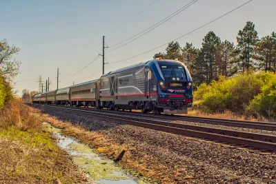 An Amtrak passenger train is shown on a spring day, rolling through a rural area in Missouri.