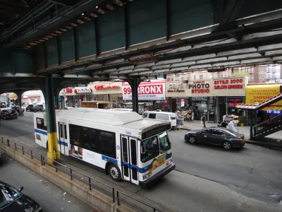 A New York MTA drives down the straight under elevated train tracks in the Bronx in New York City
