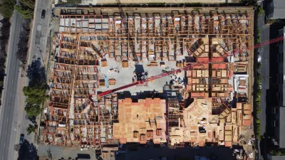 An overhead image of a large wooden building as it's being constructed.