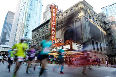 Runner passing the Chicago Theater are blurred as they pass by the camera for a race on the streets of Downtown Chicago.
