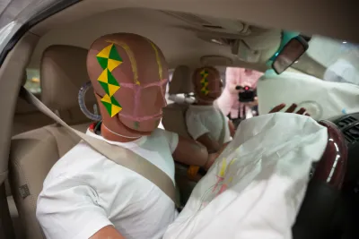 A pair of crash test dummies in a car after a crash with air bags deployed.