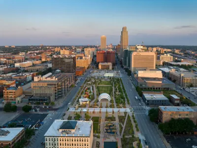 An aerial view of a park and the streets and high-rises of Downtown Omaha.
