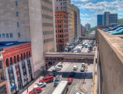 A busy street in Duluth, full of cars and buses.