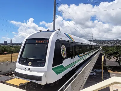White Honolulu Skyline train on elevated track.
