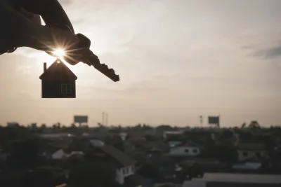 Hand holding house keys on house-shaped keychain