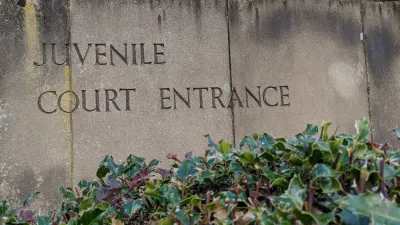 Weathered stone slabs with the words Juvenile Court Entrance engraved into it.