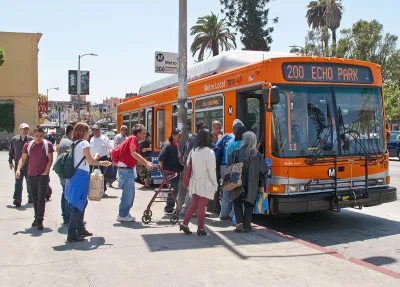 Bus passengers boarding an orange Los Angeles Metro bus on Sunset Boulevard.