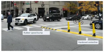 Crosswalk in Chicago with newly installed yellow delineators and speed bumps