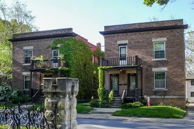 Side-by-side brick duplexes pictured on a sunny day.