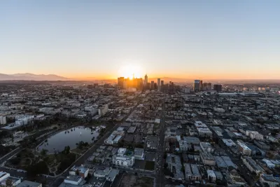 An aerial view of Los Angeles at dawn, with Westlake and MacArthur Park in the foreground and Downtown Los Angeles in the background.