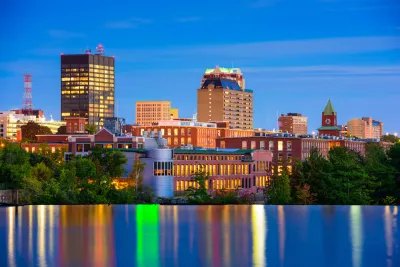 The downtown of Mancheste, New Hampshire is nestled against the Merrimack River in the final light of day.